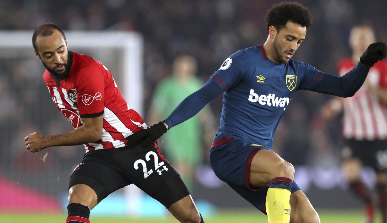 Pemain West Ham United, Felipe Anderson, berebut bola dengan pemain Southampton, Nathan Redmond, pada laga Premier League di Stadion St Mary, Kamis (27/12). West Ham United menang 2-1 atas Southampton. (AP/Andrew Matthews)