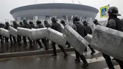 Polisi anti huru-hara berlari saat melakukan latihan di depan stadion sepak bola yang baru dibangun di Saint Petersburg di Rusia, Selasa (17/4). Turnamen tersebut diselenggarakan di Rusia pada 14 Juni hingga 15 Juli 2018. (AP Photo/Dmitri Lovetsky)
