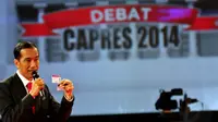 Capres Jokowi menunjukkan Kartu Indonesia Sehat saat  acara Debat Capres 2014 di Jakarta, Minggu (15/614) (Liputan6.com/Johan Tallo)