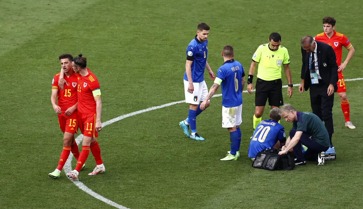 Pemain Wales Gareth Bale (kedua kiri) memeluk rekan setimnya Ethan Ampadu usai dia mendapat kartu merah karena melanggar pemain Italia Federico Bernardeschi pada pertandingan Grup A Euro 2020 di Stadion Olimpiade Roma, Italia, Minggu (20/6/2021). Italia menang 1-0. (Ryan Pierse/Pool via AP)