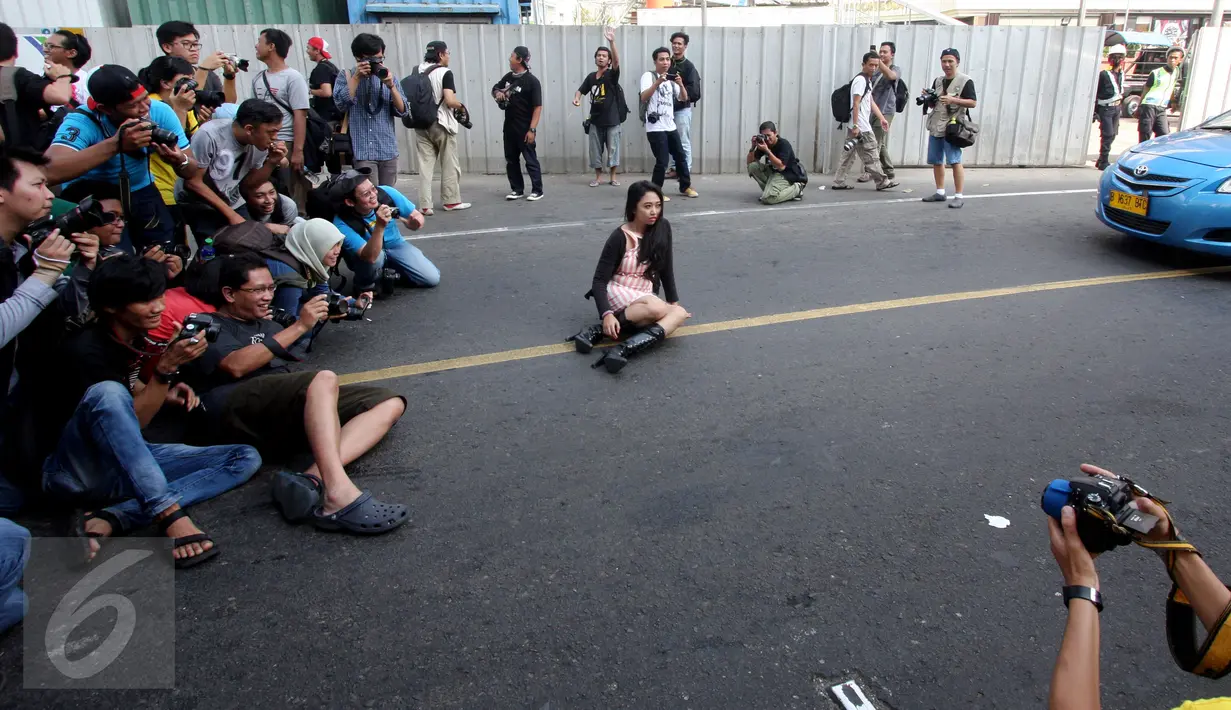 Para fotografer melakukan pemotretan seorang model di Jalan MH Thamrin, Jakarta, Minggu (19/7/2015). Momen Jakarta sepi akibat banyak yang mudik, dimanfaatkan fotografer untuk memotret model. (Liputan6.com/Johan Tallo)