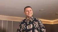 Pelatih Timnas Bulgaria, Aleksandar Dimitrov tersenyum lebar usai menerima hadiah kemeja batik dari Bola.com usai sesi wawancara di Ayana Midplaza, Jakarta, Rabu (25/3/2026). (Bola.com/Nur Iman Ali)