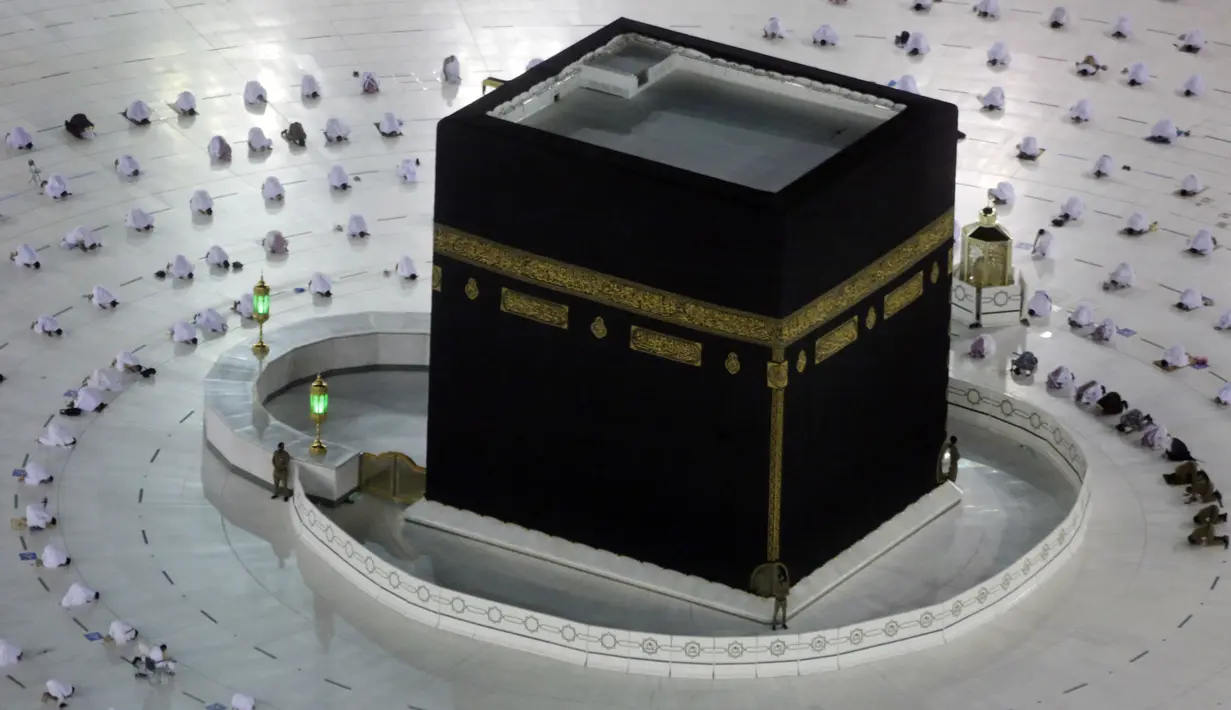 Jemaah umrah menerapkan jaga jarak untuk membantu mengekang penyebaran virus corona COVID-19 saat sholat mengelilingi Ka'bah pada awal bulan suci Ramadhan di Masjidil Haram, Mekkah, Arab Saudi, Senin (12/4/2021). (AP Photo/Amr Nabil)