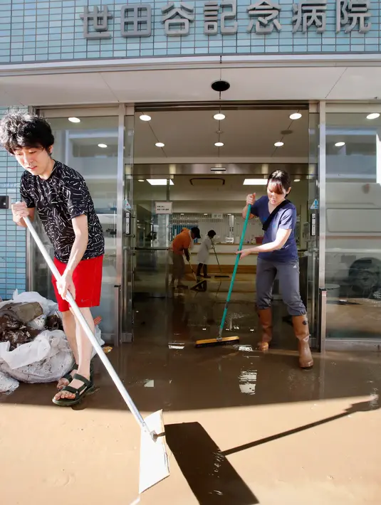 Orang-orang membersihkan rumah sakit yang terkena banjir setelah topan Hagibis melanda Tokyo, Minggu (13/10/2019).  Topan Hagibis di Jepang akhir pekan ini  disebut sebagai badai terburuk sejak 60 tahun terakhir yang pernah melanda Negeri Sakura. (Kyodo News via AP)