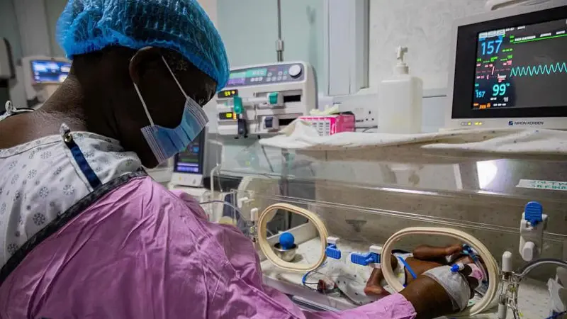 Seorang ibu di Uganda, Namukwaya, memeriksa bayi kembarnya di dalam inkubator di Rumah Sakit Internasional dan Pusat Kesuburan Wanita. (FOTO: AFP)