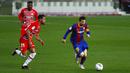Pemain Barcelona Lionel Messi (kanan) menggiring bola melewati pemain Granada Yangel Herrera pada pertandingan La Liga di Stadion Camp Nou, Barcelona, Spanyol, Kamis (29/4/2021). Barcelona kalah 1-2. (AP Photo/Joan Monfort)