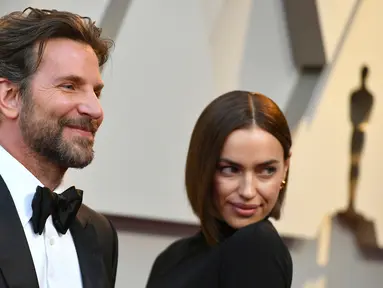 Aktor Bradley Cooper dan model asal Rusia, Irina Shayk  menghadiri perhelatan Oscar 2019 di Dolby Theatre, Los Angeles, Minggu (24/2). Di tengah isu kedekatannya dengan Lady Gaga, Cooper justru tampil mesra dengan Irina Shayk. (Jordan Strauss/Invision/AP)