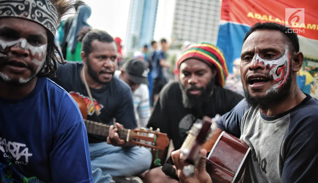 Eks pekerja PT Freeport Indonesia bermain musik saat menggelar aksi selama Car Free Day di kawasan Bunderan HI, Jakarta, Minggu (30/12). Sebanyak 3.274 pekerja Freeport diberhentikan secara sepihak oleh manajemen. (Liputan6.com/Faizal Fanani)