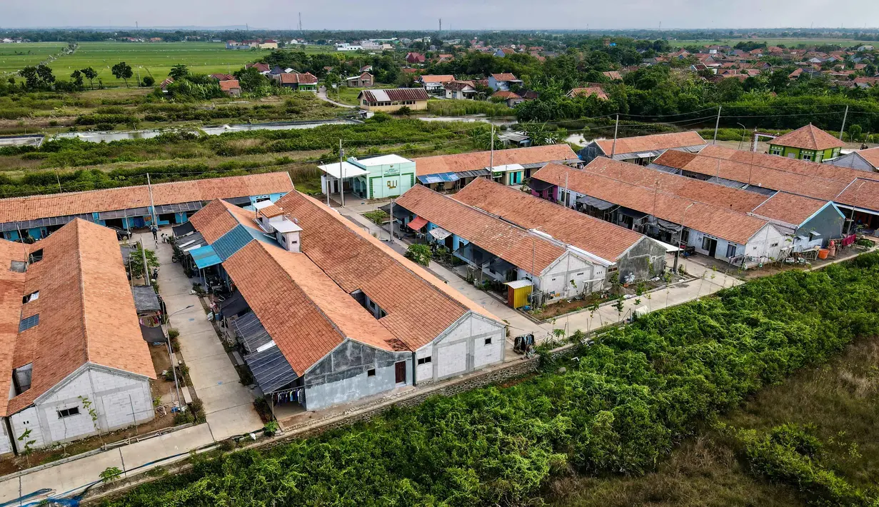 Namun, proyek ini juga menimbulkan kekhawatiran terkait dampak lingkungan, sosial, dan biaya yang besar. Tampak dalam foto yang diambil pada 29 Juli 2025 menunjukkan pemandangan udara dari perumahan baru yang dibangun oleh pemerintah untuk menggantikan rumah-rumah yang hilang akibat kenaikan air laut akibat perubahan iklim, di Desa Semonet, Pekalongan, Jawa Tengah. (BAY ISMOYO/AFP)