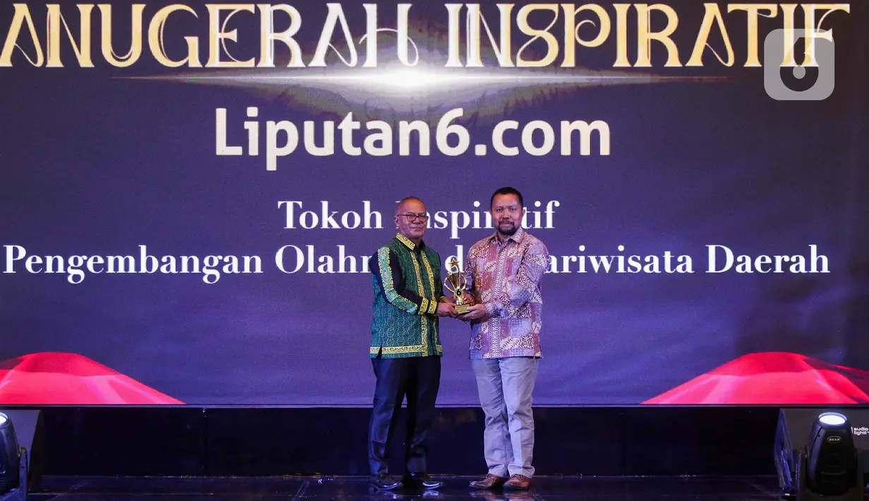 Chief Content Officer (COO) KapanLagi Youniverse, Wens Manggut  (kanan) memberikan plakat kepada perwakilan Bupati Paser  saat acara Anugerah Inspiratif Liputan6.com di hotel Shangri La, Jakarta, Rabu (31/7/2024). Bupati Paser dr. Fahmi Fadli menerima  penghargaan Tokoh Inspiratif Pengembangan Olahraga dan Pariwisata Daerah. (Liputan6.com/Herman Zakharia)