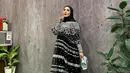 Dress dari @khanaan.official itu dipadukannya bersama pashmina warna hitam dan hand bag warna putih. [@nindyayunda]