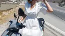 Luna Maya tak ragu naik motor mengenakan mini dress putih berlengan lebar dan lace collar yang manis [@lunamaya]