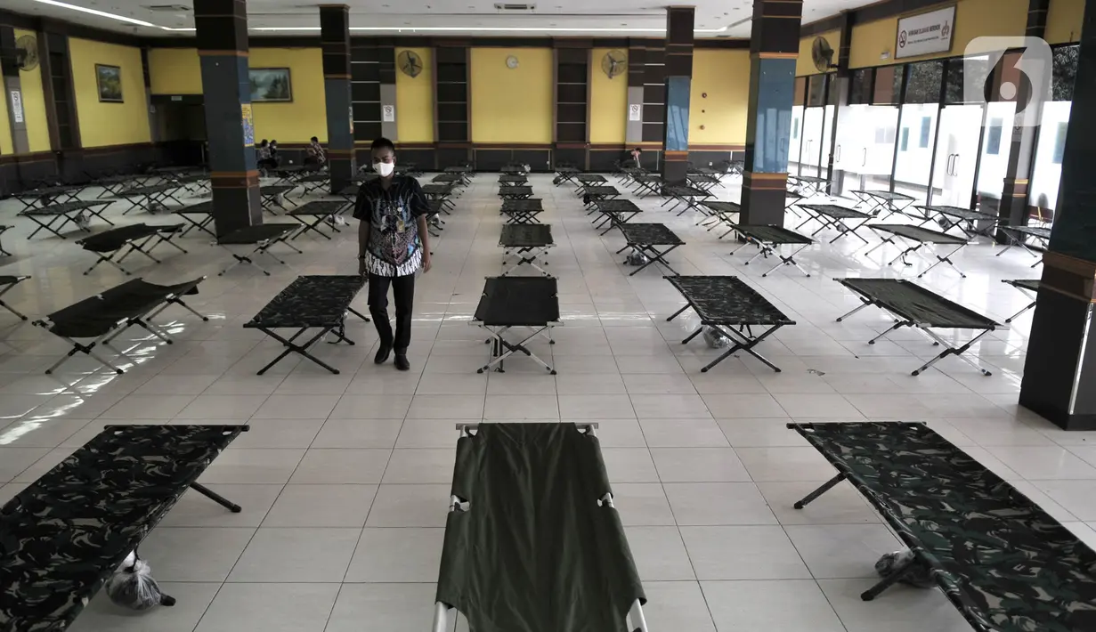 Petugas memeriksa ranjang yang disiapkan untuk karantina pemudik di Gelanggang Remaja Pulogadung, Rawamangun, Jakarta, Kamis (28/5/2020). Gelenggang ini dijadikan lokasi karantina bagi pemudik atau pendatang yang tidak memiliki SIKM saat tiba di Ibu Kota via bus AKAP. (merdeka.com/Iqbal S. Nugroho)