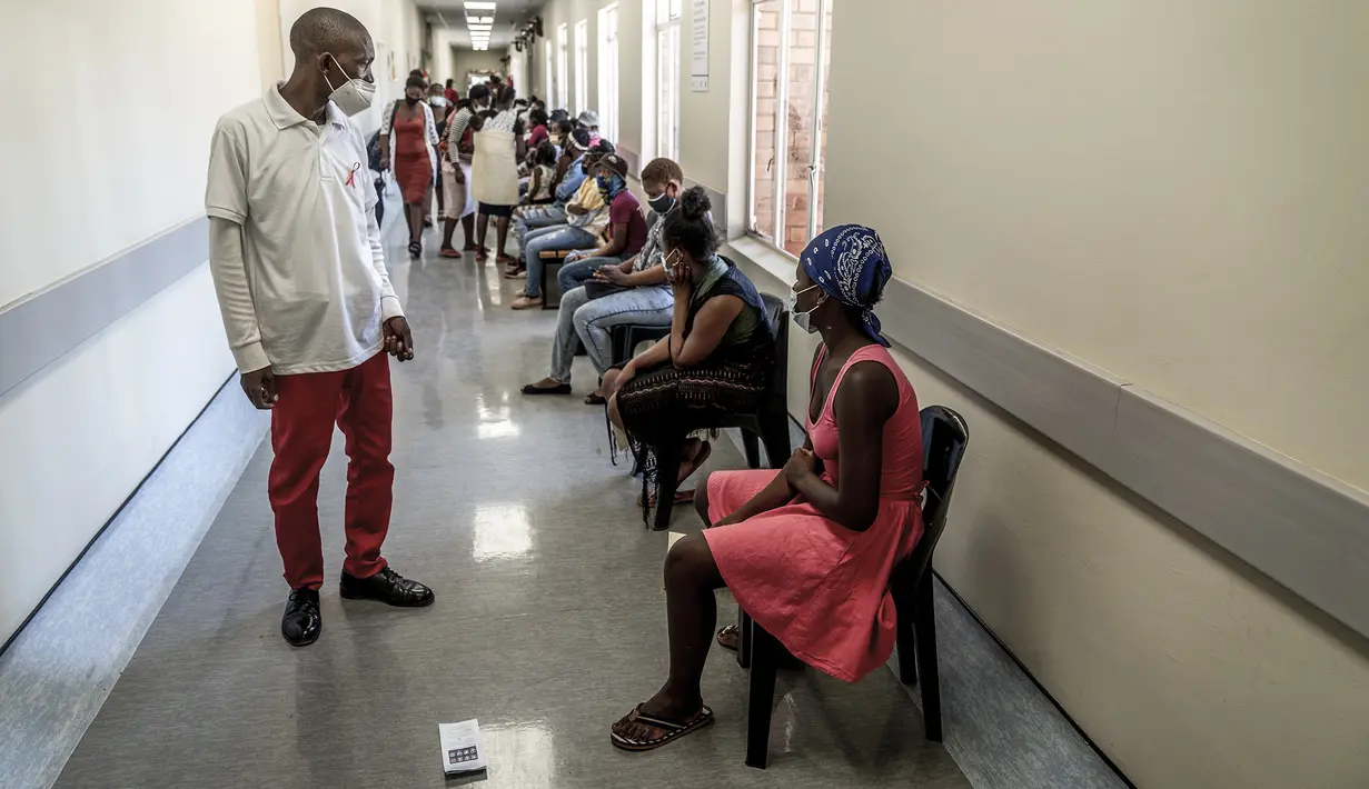 Pekerja memastikan orang-orang menjaga jarak saat antre untuk divaksinasi COVID-19 di RS Lenasia South, dekat Johannesburg, Rabu (1/12/2021). Dokter Afrika Selatan mengatakan peningkatan pesat kasus COVID-19 yang dikaitkan dengan varian baru omicron memiliki gejala ringan (AP Photo/ Shiraaz Mohamed)
