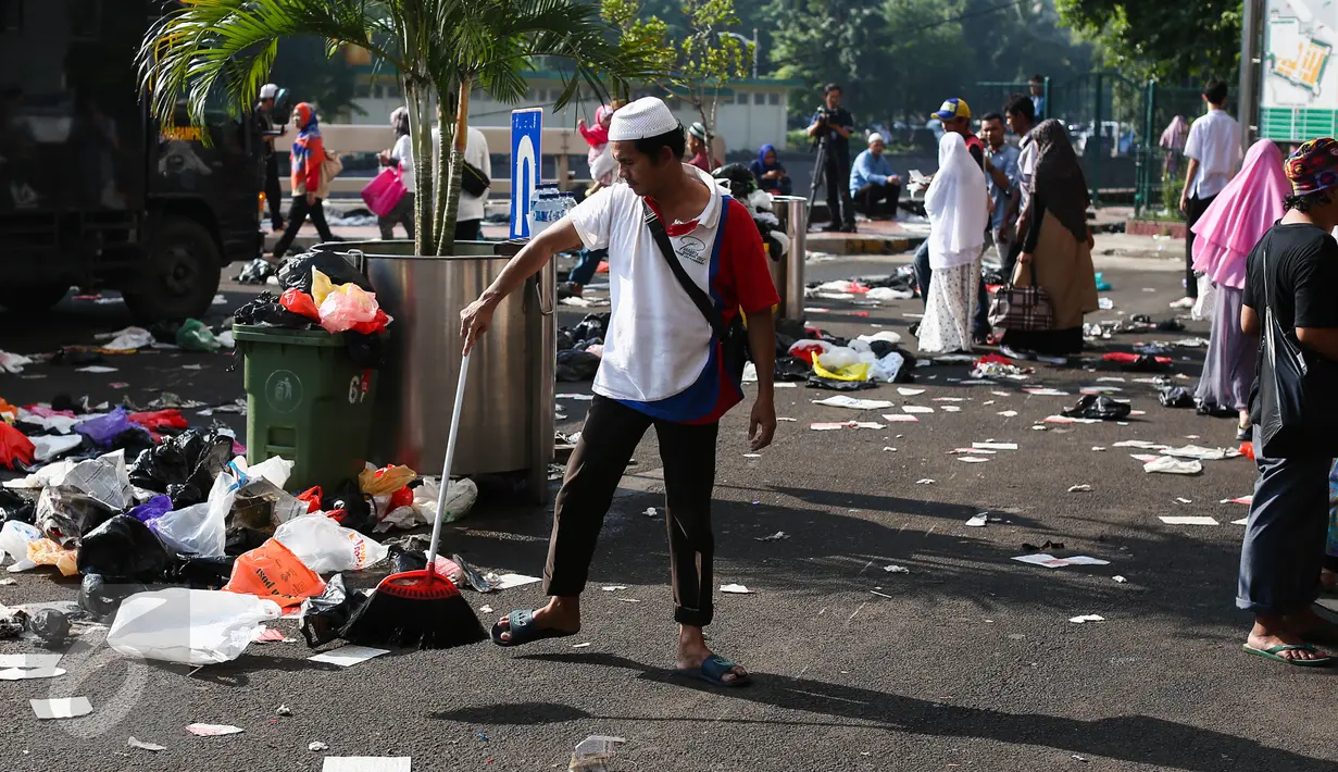 Petugas membersihkan sampah-sampah yang berserakan di area Masjid Istiqlal, Jakarta, Rabu (6/7). Sampah-sampah plastik bekas bungkus sepatu jemaah saat salat Id dibuang begitu saja di halaman masjid. (Liputan6.com/Faizal Fanani)
