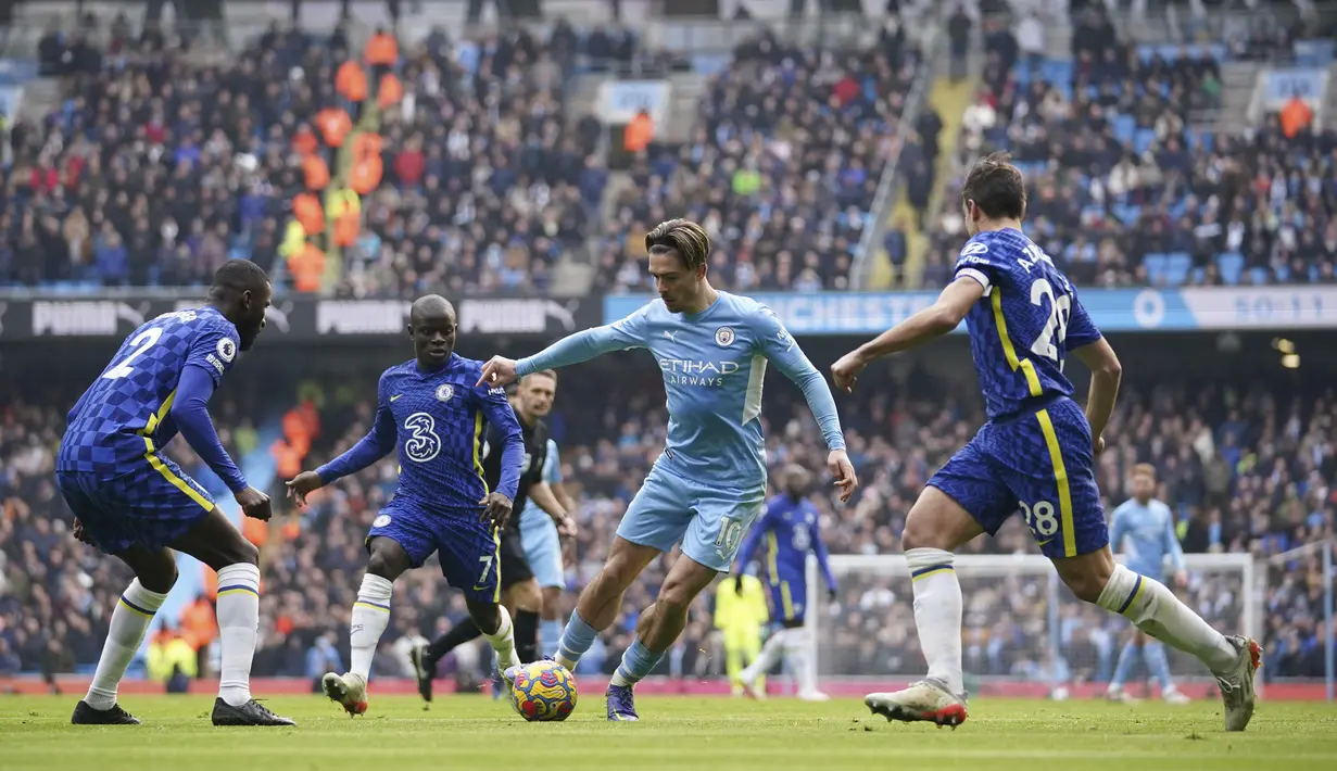 Gelandang Manchester City, Jack Grealish (tengah) mencoba menerobos pertahanan Chelsea saat pertandingan lanjutan Liga Inggris di stadion Etihad, Inggris, Sabtu (15/1/2022). Hasil ini membuat Man City unggul 13 poin atas Chelsea yang menempati peringkat dua di klasemen. (AP Photo/Dave Thompson)