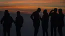 Wisatawan menikmati suasana puncuk Gunung Bromo selama Festival Yadnya Kasada di Probolinggo, Jawa Timur (10/7). Warga Tengger melakukan ritual lempar hasil bumi sebagai wujud syukur pada Sang Hyang Widi. (AFP Photo/Juni Kriswanto)