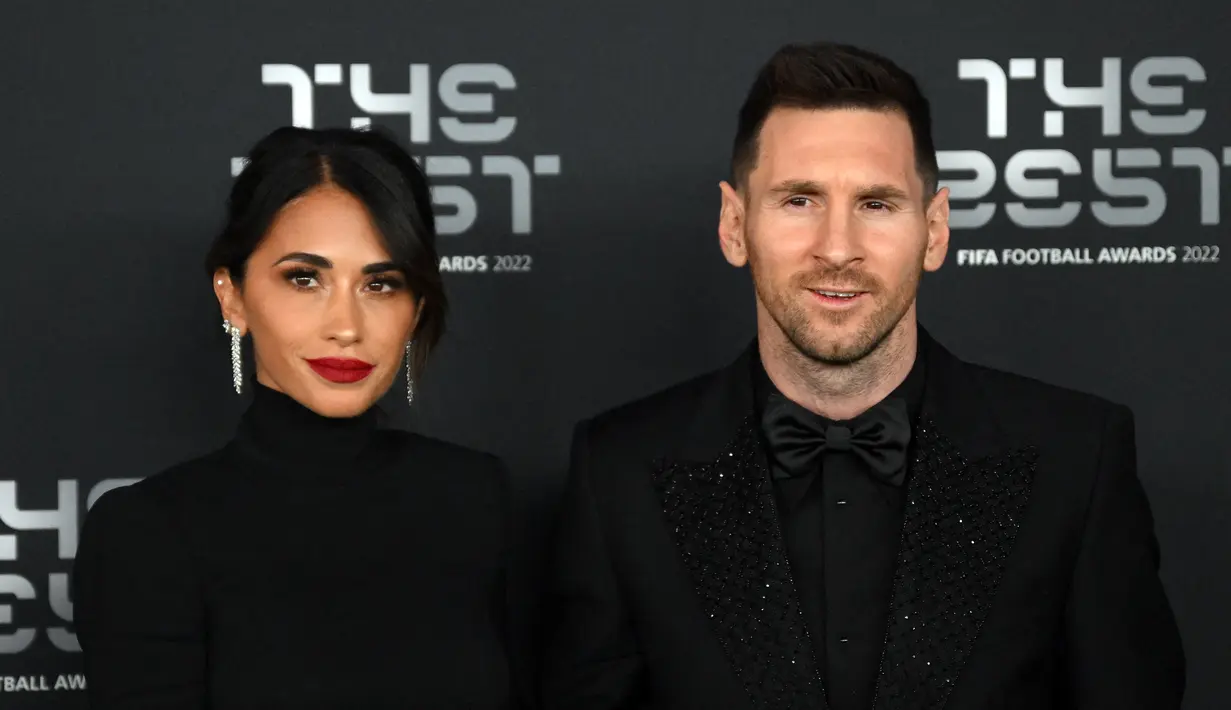 Pemain Paris Saint-Germain asal Argentina, Lionel Messi (kanan) dan istrinya Antonela Roccuzzo berpose setibanya pada acara The Best FIFA Football Awards 2022 di Paris, Prancis, 27 Februari 2023. Messi dan Antonella mencuri perhatian saat menghadiri The Best FIFA Football Awards 2022. (FRANCK FIFE/AFP)