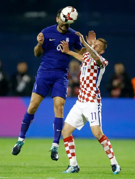 Pemain Yunani, Alexandros Tziolis berebut bola dengan pemain Kroasia, Marcelo Brozovic pada leg pertama playoff Piala Dunia 2018 di Stadion Maksimir, Jumat (10/11). Kroasia memperbesar peluangnya lolos ke putaran final usai menang 4-1. (AP/Darko Bandic)
