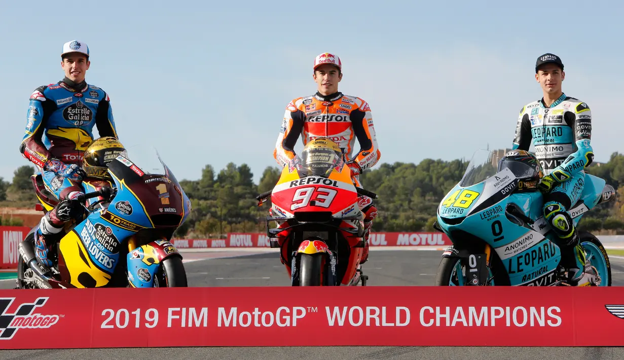 Pembalap MotoGP Marc Marquez (tengah) bersama pembalap Moto2 Alex Marquez (kiri) dan pembalap Moto3 Lorenzo Dalla Porta (kanan) berpose di depan Valencia Motorcycle Grand Prix, Spanyol, Minggu (17/11/2019). Ketiganya sukses merebut gelar juara dunia tahun 2019. (AP Photo/Alberto Saiz)
