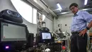 Profesor Viboon Sangveraphunsiri berdiri dekat robot medis yang dimodifikasi untuk memeriksa pasien virus corona COVID-19 di Regional Center of Robotics Technology, Chulalongkorn University, Bangkok, Thailand, Rabu (18/3/2020). Robot dikerahkan membantu memerangi COVID-19. (LILLIAN SUWANRUMPHA/AFP)