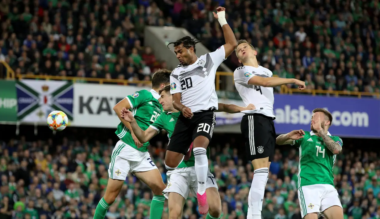 Gelandang dan bek Jerman, Serge Gnabry (tengah) dan Matthias Ginter (dua kanan) menyundul bola udara saat menghadapi Irlandia Utara dalam kualifikasi Euro 2020 di Windsor Park, Belfast, Senin (9/9/2019). Jerman mengalahkan Irlandia Utara 2-0. (Paul Faith/AFP)