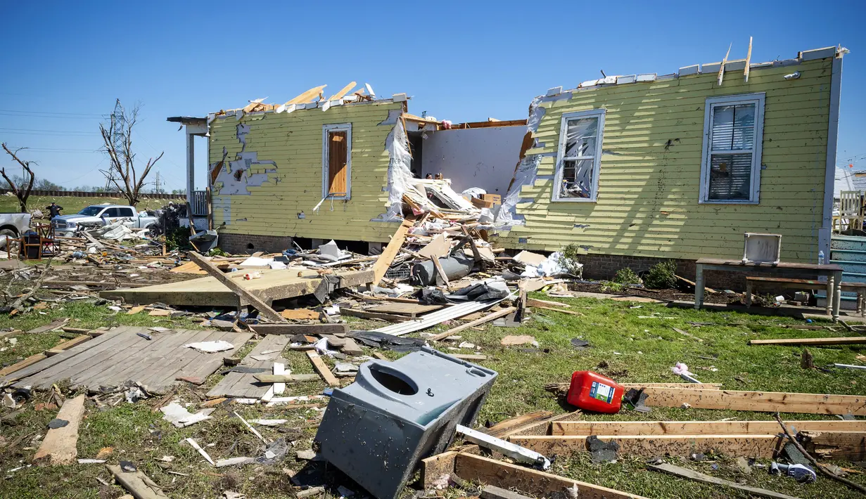 Puing-puing berserakan di tanah di samping rumah yang rusak parah setelah tornado melanda daerah itu Selasa (22/3) malam sebelumnya di Arabi, La., Rabu (23/3/2022). (Scott Clause/The Daily Advertiser via AP)