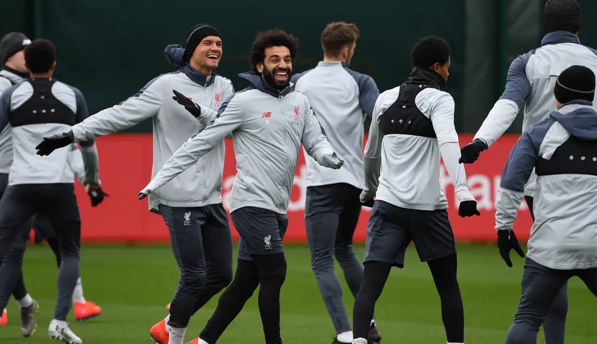 Gelandang Liverpool Mohamed Salah (tengah) bercanda dengan rekan setimnya saat sesi latihan jelang menghadapi Bayern Munchen dalam leg kedua babak 16 besar Liga Champions di Melwood, Liverpool, Inggris, Selasa (12/3). (Paul ELLIS/AFP)