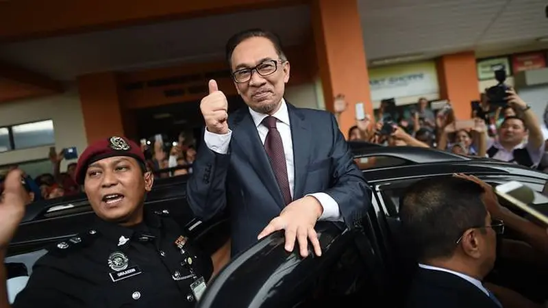 Anwar Ibrahim mengacungkan jempol kepada para pendukungnya di Rumah Sakit Rehabilitasi Cheras, Kuala Lumpur. Tindakan itu mengafirmasi statusnya sebagai orang yang bebas, usai menerima pengampunan dari Raja Malaysia (16/5) (Mohd Rasfan / AFP PHOTO)