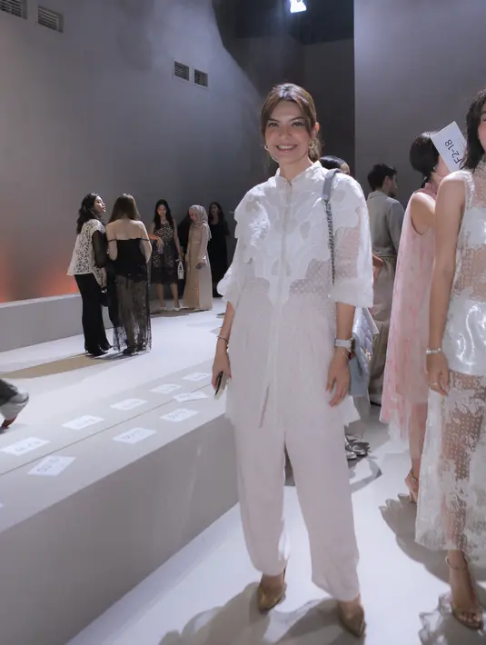 Najwa Shihab juga terlihat di gelaran Sapto Djojokartiko SS24. Ia tampil menawan dalam balutan atasan dan celana panjang putih. [Foto: Document/FIMELA]