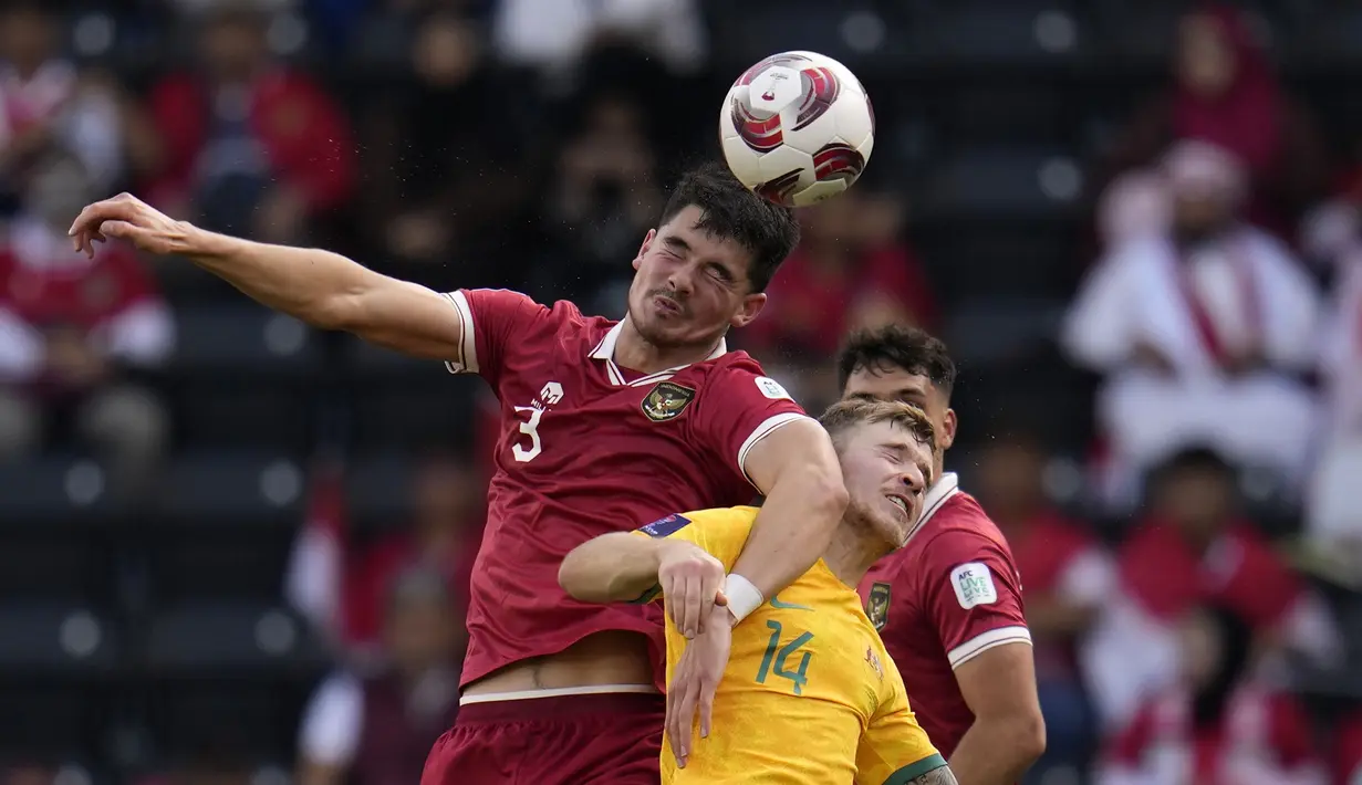 Pemain Timnas Indonesia, Elkan Baggot (kiri) berduel udara dengan pemain Australia, Riley McGree pada laga 16 besar Piala Asia 2023 yang berlangsung di assim bin Hamad Stadium, Doha, Qatar, Minggu (28/01/2024). (AP Photo/Aijaz Rahi)
