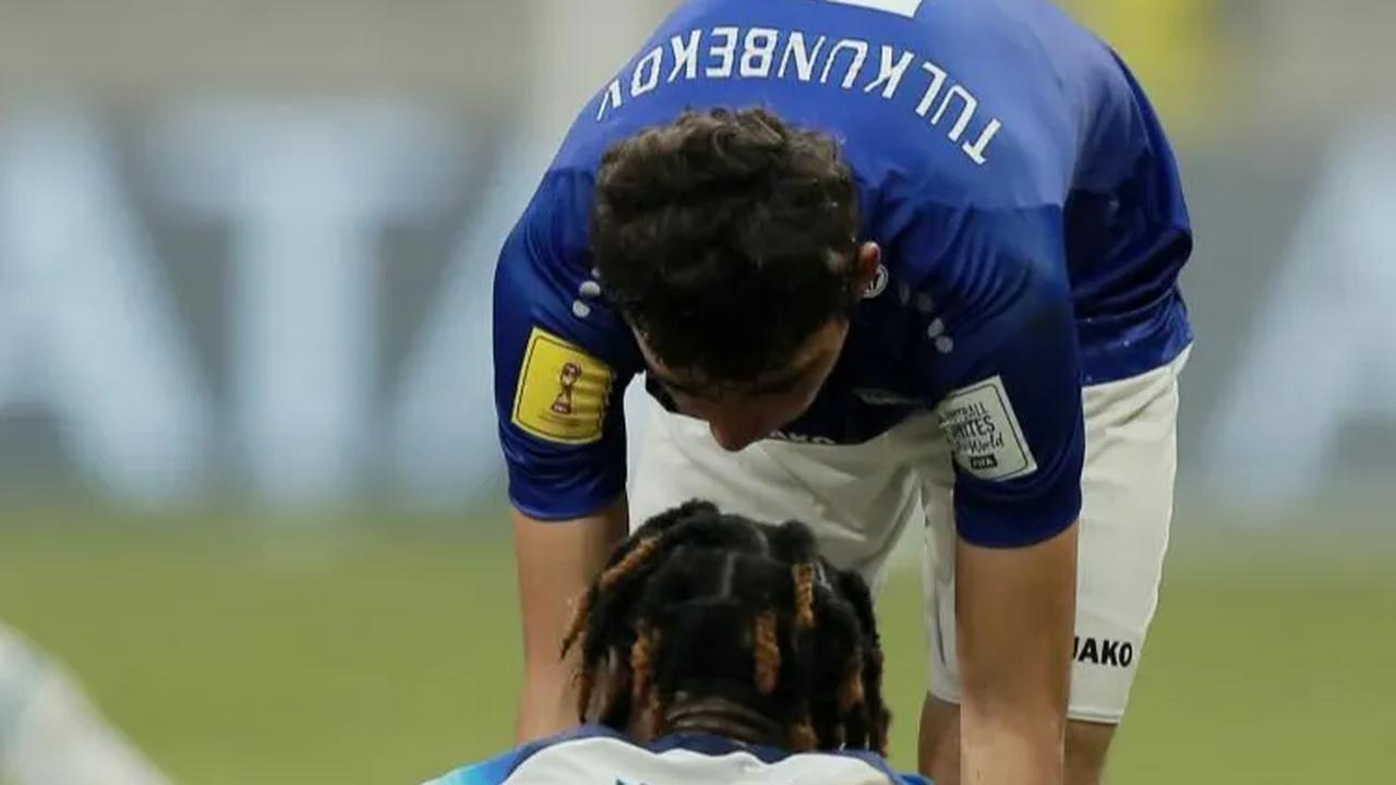 Pemain Uzbekistan U-17, Azizbek Tulkunbekov, berusaha menguatkan pemain Inggris U-17, Joel Ndala, yang kecewa setelah kalah pada babak 16 besar Piala Dunia U-17 2023.
