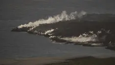 Lava dari gunung berapi Cumbre Vieja mengalir ke Samudra Atlantik terlihat dari Puerto de Naos, di Pulau Canary La Palma (4/10/2021). Aliran baru lava yang sangat cair muncul dari gunung berapi yang meletus di pulau Canary Spanyol pada 1 Oktober, kata pihak berwenang. (AFP/Jorge Guerrero)