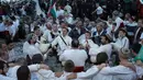 Sejumlah pria Bulgaria memainkan alat musik tradisional sambil menari di perairan sungai Tundzha selama Hari Epiphany di kota Kalofer, Bulgaria (6/1). Kegiatan ini juga dapat membawa kesehatan yang baik sepanjang tahun baru. (AP Photo/Valentina Petrova)