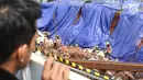 Lereng galian pondasi pembangunan tiang pancang proyek LRT dan flyover Pancoran yang longsor ditutupi kain terpal, Jakarta, Jumat (13/10). (Liputan6.com/Immanuel Antonius)