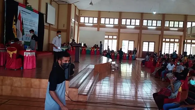 Ratusan mahasiswa dan masyarakat sedang antri mengikuti vaksinasi Covid-19 di aulah STFK Ledalero`(Liputan6.com/Dionisius Wilibardus)