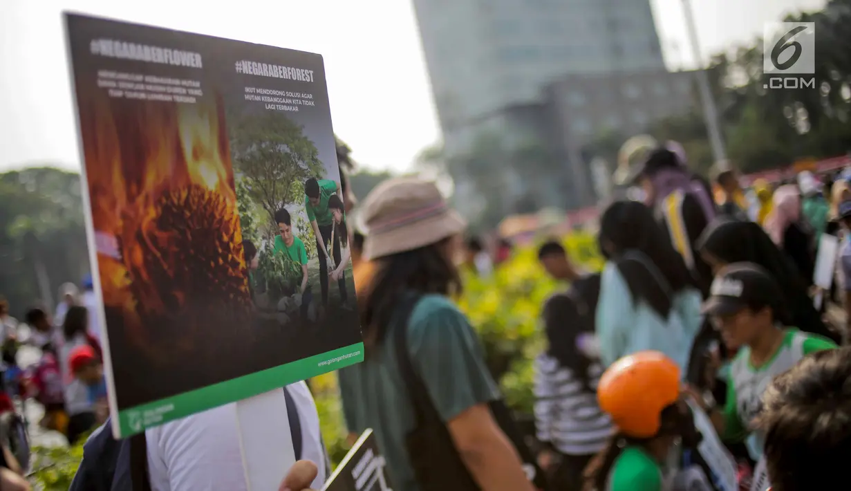 Anggota Walhi Jakarta membawa poster saat menggelar aksi melawan asap dan peduli satwa dalam CFD di Bundaran HI, Jakarta, Minggu (15/9/2019). Walhi menuntut pemerintah segera menyelesaikan permasalahan kebakaran hutan yang berdampak buruk bagi manusia dan lingkungan. (Liputan6.com/Faizal Fanani)