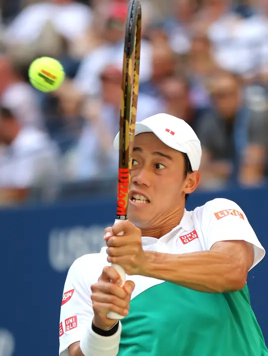 Petenis Jepang, Kei Nishikori mengembalikan bola ke arah Marin Cilic dari Kroasia pada perempat final AS Terbuka di New York, Rabu (5/9). Pertandingan Nishikori versus Cilic berlangsung ketat selama lebih dari empat jam. (ELSA/GETTY IMAGES /AFP)