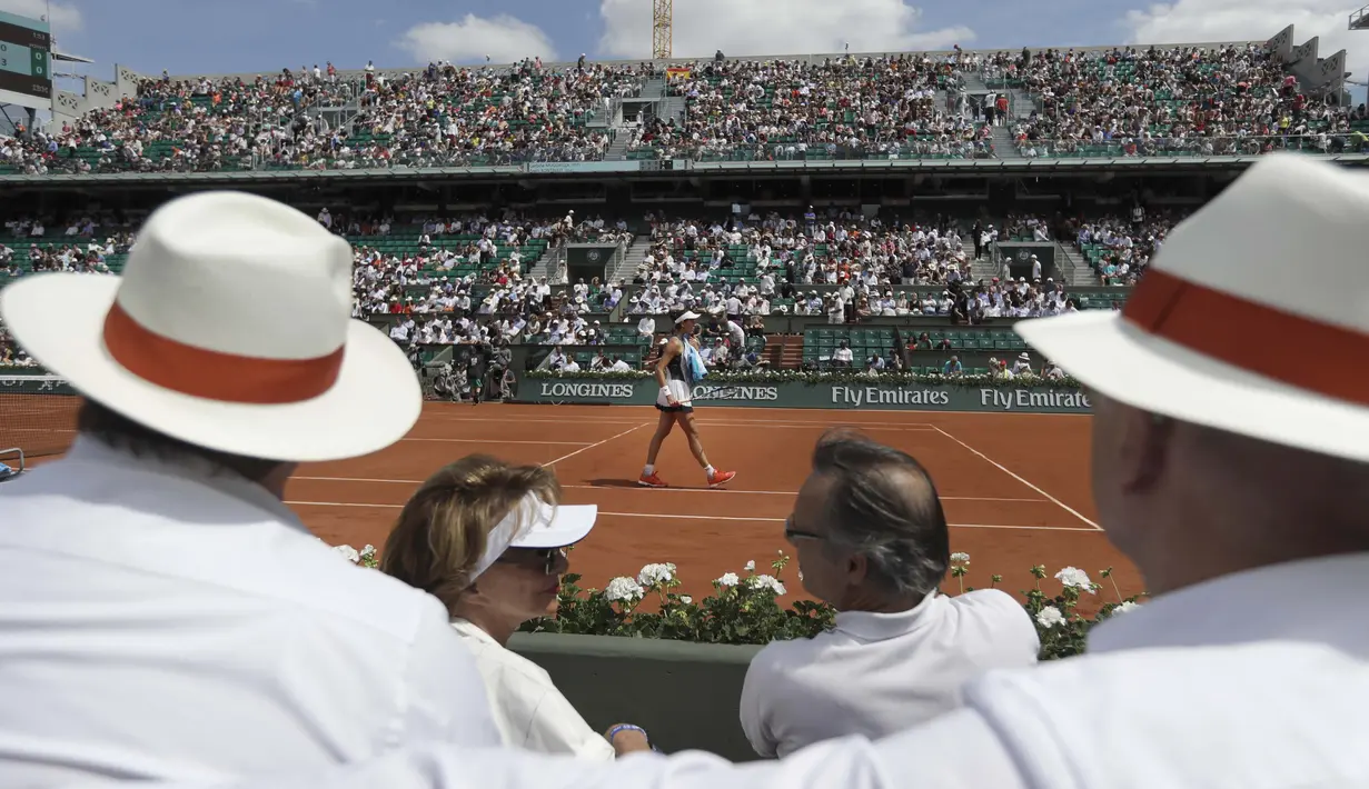 Garbine Muguruza berjalan sambil membersihkan wajahnya dari keringat saat melawan Anett Kontaveit pada ajang Prancis Terbuka di Roland Garros stadium, Paris, (31/5/2017). (AP/Petr David Josek)