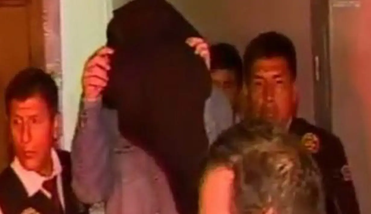 Joshuo Brown (tengah) saat digelandang polisi keluar dari tempat penginapannya di Lima, Peru, (5/12). Joshua Brown diduga merupakan salah satu pimpinan sindikat perdagangan manusi terbesar di Amerika Selatan. (cdn2.scmp.com)