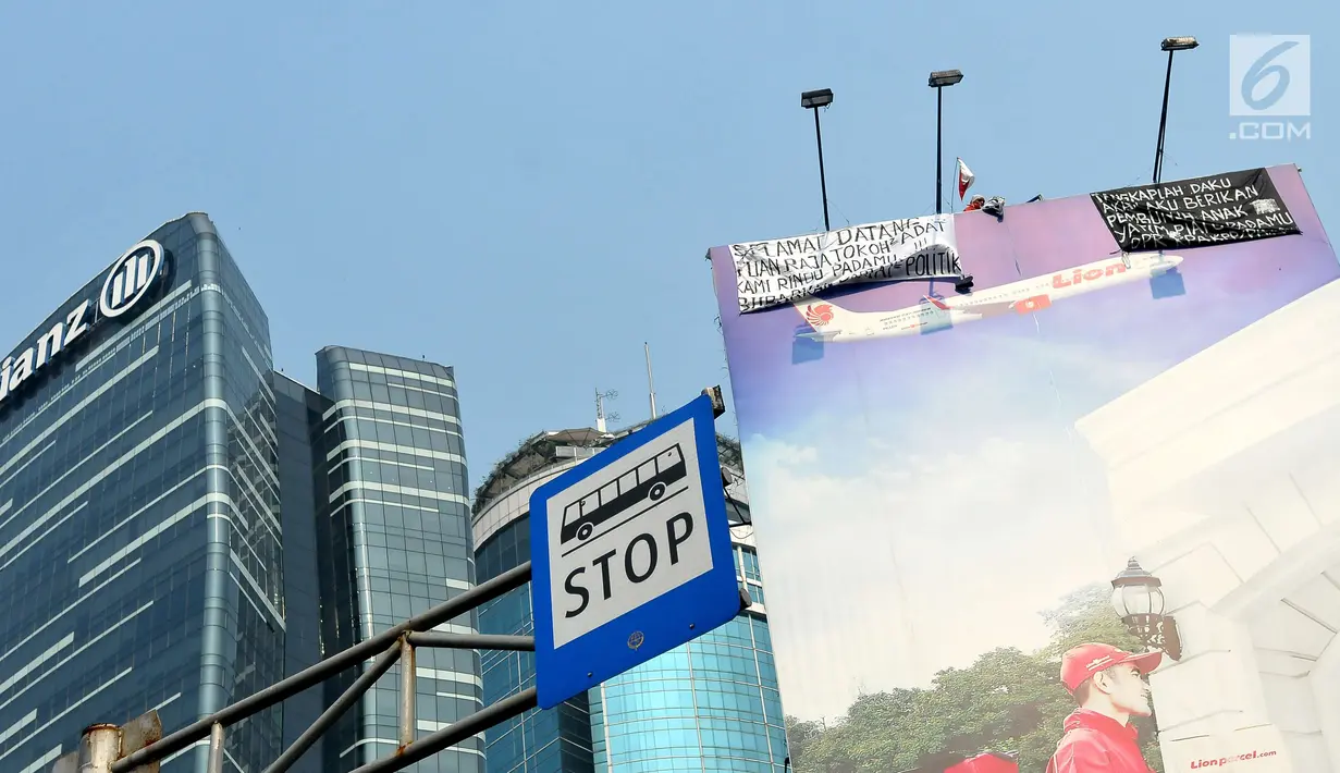 Agustinus Woro alias Martinus saat berada di baliho di seberang Kantor Pelayanan Pajak Pratama Setiabudi Satu, Jakarta, Jumat (26/5).  Sebelum turun, Agustinus minta dibelikan nasi padang dengan lauk ikan tongkol. (Liputan6.com/Helmi Afandi)
