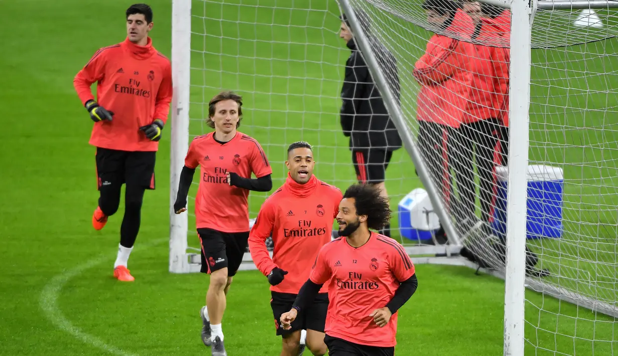 Bek Real Madrid Marcelo bersama Luka Modric, Mariano, dan Thibaut Courtois berlari saat berlatih jelang melawan Ajax Amsterdam pada leg pertama babak 16 besar Liga Champions di Johan Cruijff Arena, Amsterdam, Belanda, Selasa (12/2). (EMMANUEL DUNAND/AFP)