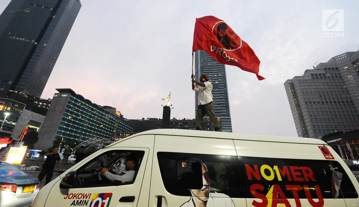 Pendukung capres-cawapres 01 Jokowi-Ma'ruf Amin saat arak-arakan di kawasan bunderan HI, Jakarta, Rabu (17/4). Pendukung capres-cawapres 01 arak-arakan merayakan unggul dalam versi hitungan cepat. (Liputan6.com/Herman Zakharia)