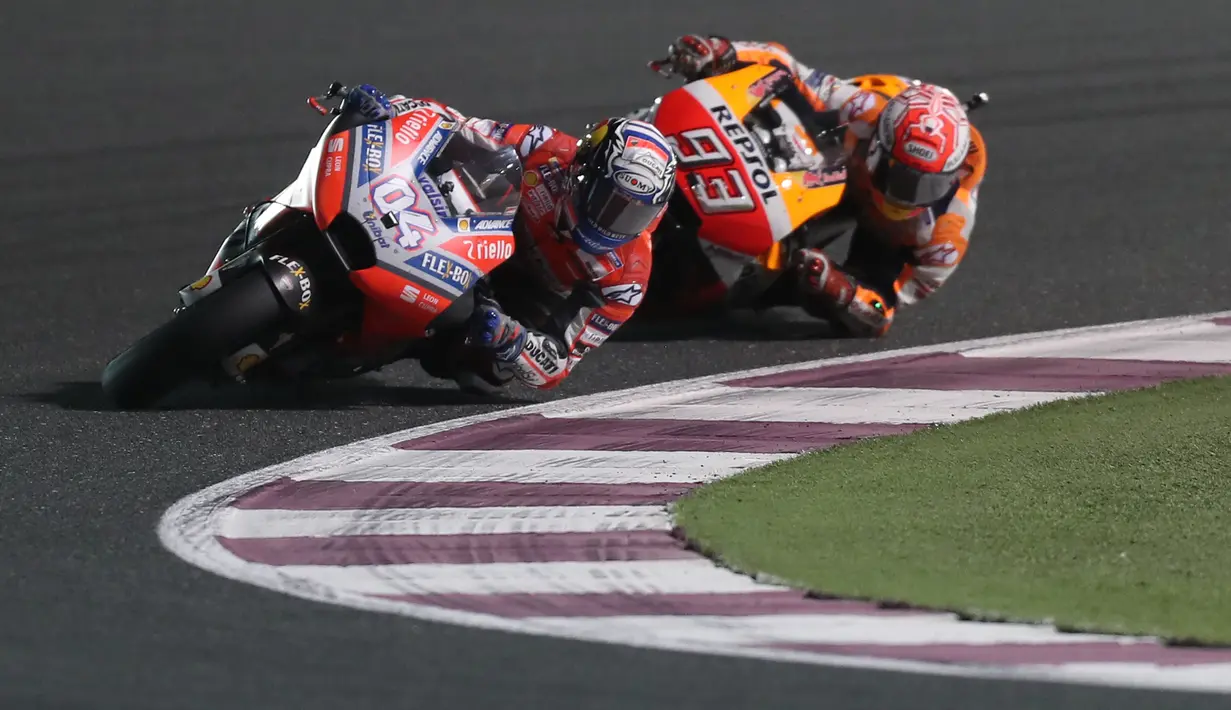 Pembalap Ducati Andrea Dovizioso beradu cepat dengan pembalap Marc Marquez saat balapan MotoGP Qatar 2018 di Sirkuit Internasional Losail (18/3). Hingga putaran terakhir Dovizioso harus bersaing ketat dengan Marc Marquez.  (AFP Photo/Karim Jaafar)