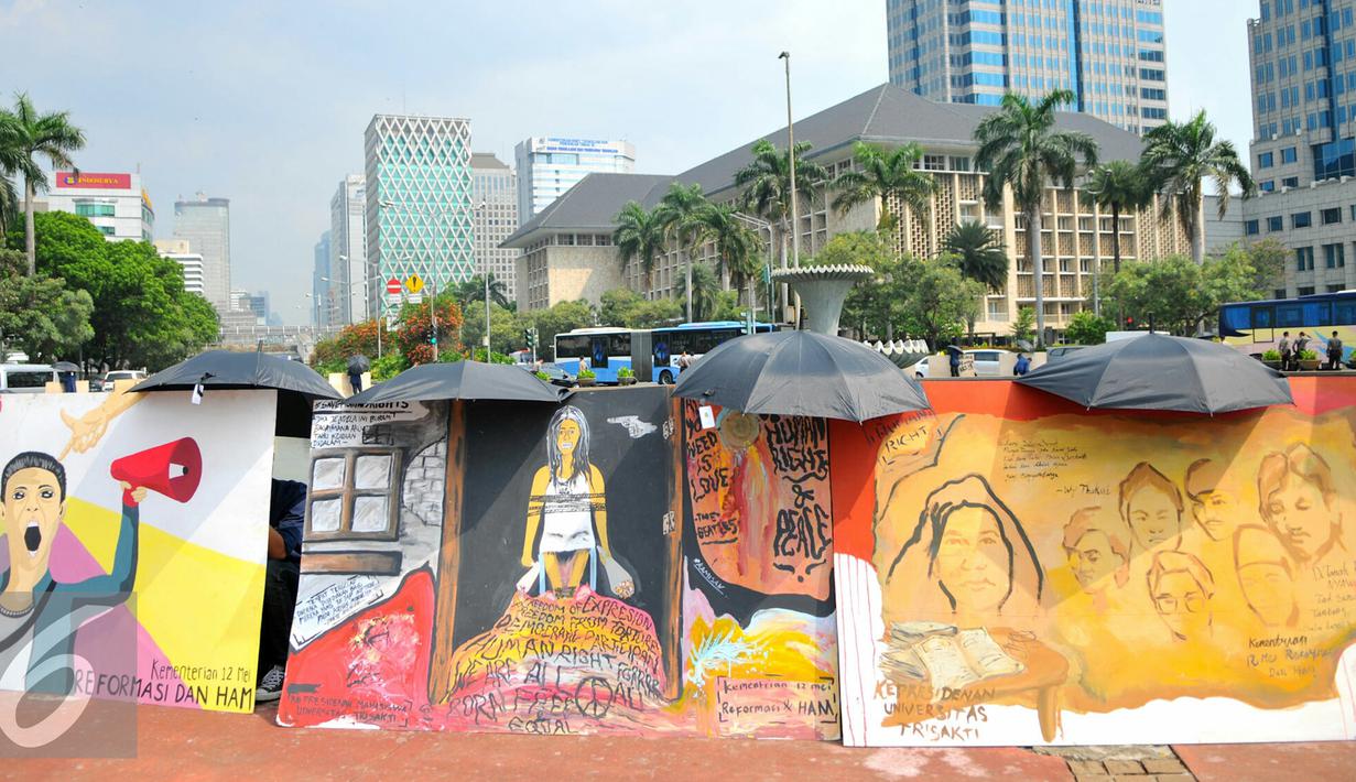 Mahasiswa Universitas Trisaksi saat menggelar lukisan mural untuk memperingati 'Tragedi Trisakti 12 Mei 1998' di bunderan patung kuda, Jakarta, Kamis (12/5). Aksi ini bertujuan untuk memperingati tragedi trisakti 12 Mei 98. (Liputan6.com/Yoppy Renato)