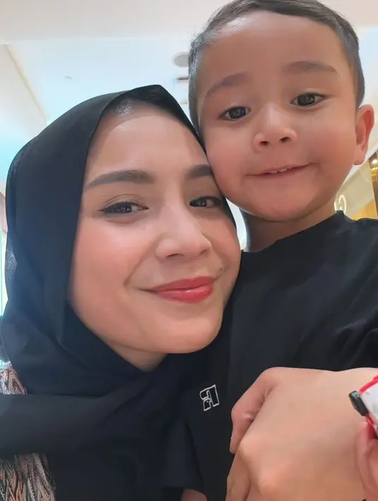 Foto bareng putra bungsunya, Rayyanza, Nagita Slavina kenakan kerudung hitam. Kali ini dipadukan dengan atasan bermotif dengan makeup minimalis. [@raffinagita1717]