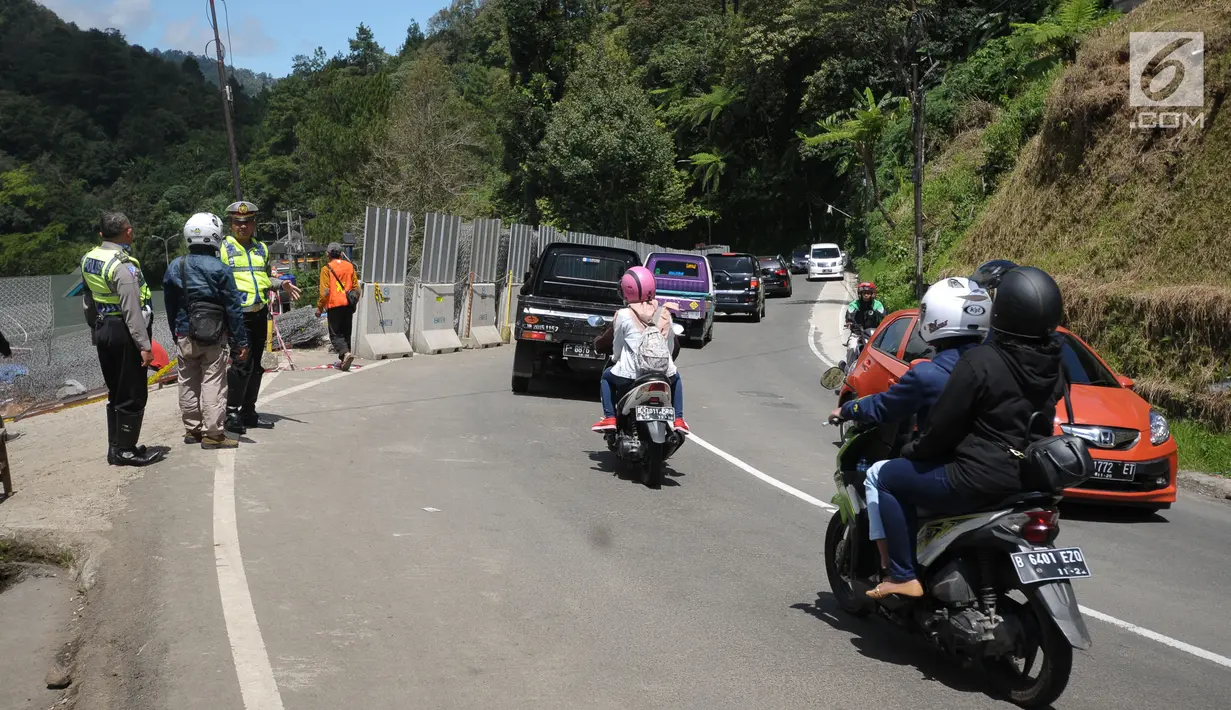 Petugas mengawasi arus lalu lintas di sekitar area yang longsor di kawasan Ciloto, Cianjur, Jabar, Sabtu (31/3). Longsor yang terjadi pada Rabu (28/3) lalu diduga adanya pergerakan tanah sehingga menyebabkan longsor. (Liputan6.com/Helmi Fithriansyah)