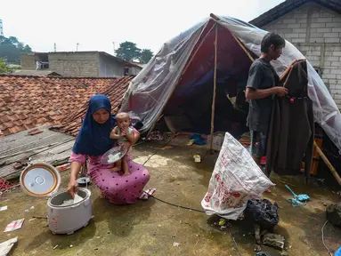 Warga beraktivitas pada tenda darurat yang dibangun di atas rumah pasca banjir melanda kawasan Pejaten Timur, Jakarta Selatan, Senin (8/1/2024). (merdeka.com/Arie Basuki)