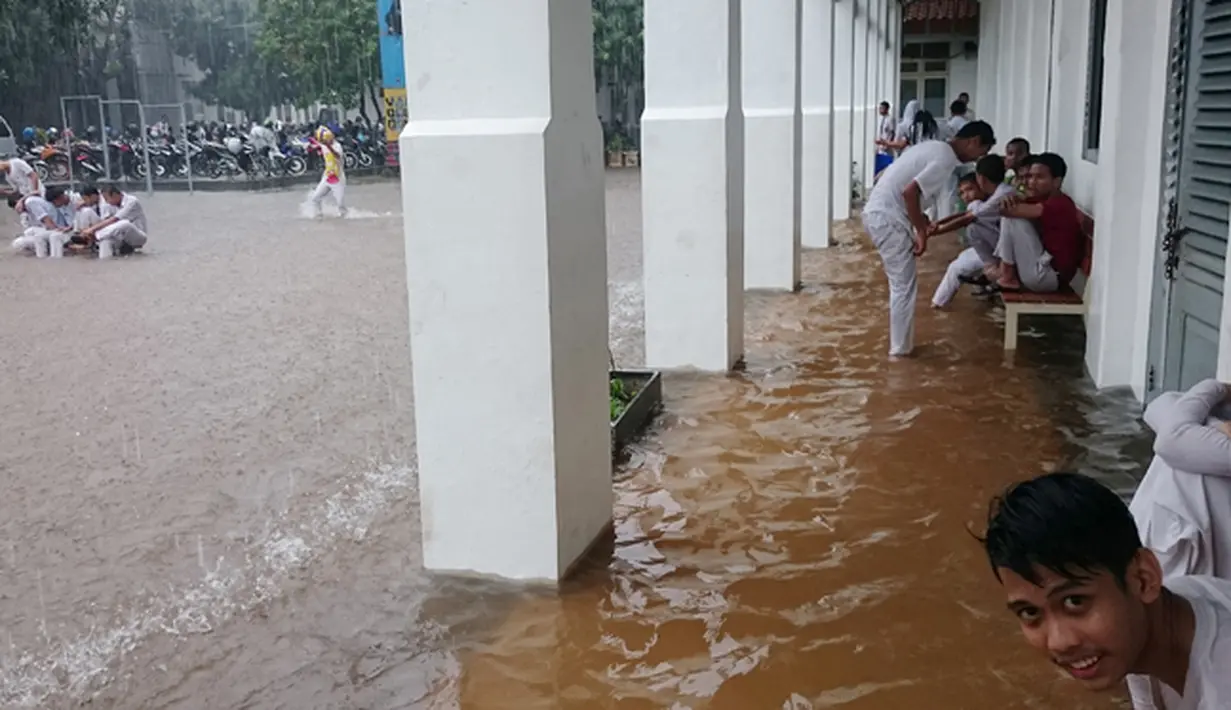 Banjir yang disebabkan hujan berkepanjangan di ibukota itu membuat sejumlah sekolah memulangkan anak didiknya lebih awal, Jakarta, Senin (9/2/2015). (Antara Foto/Fanny Octavianus)
