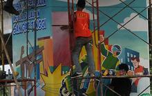 FOTO: Mural BPJS Jakarta Bebas Polusi Percantik Tiang Pancang Kolong Tol Becakayu